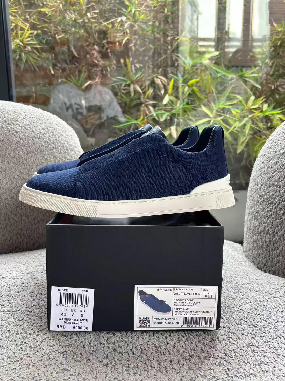 Zapatillas azul marino sobre su caja, artículo gestionado por Luxent